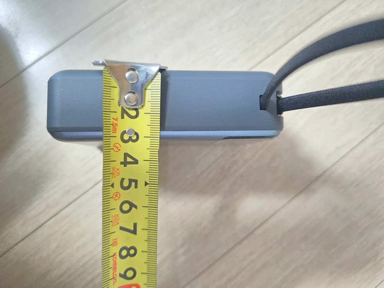 보조배터리의 두께감을 보여주는 클로즈업 측정 장면